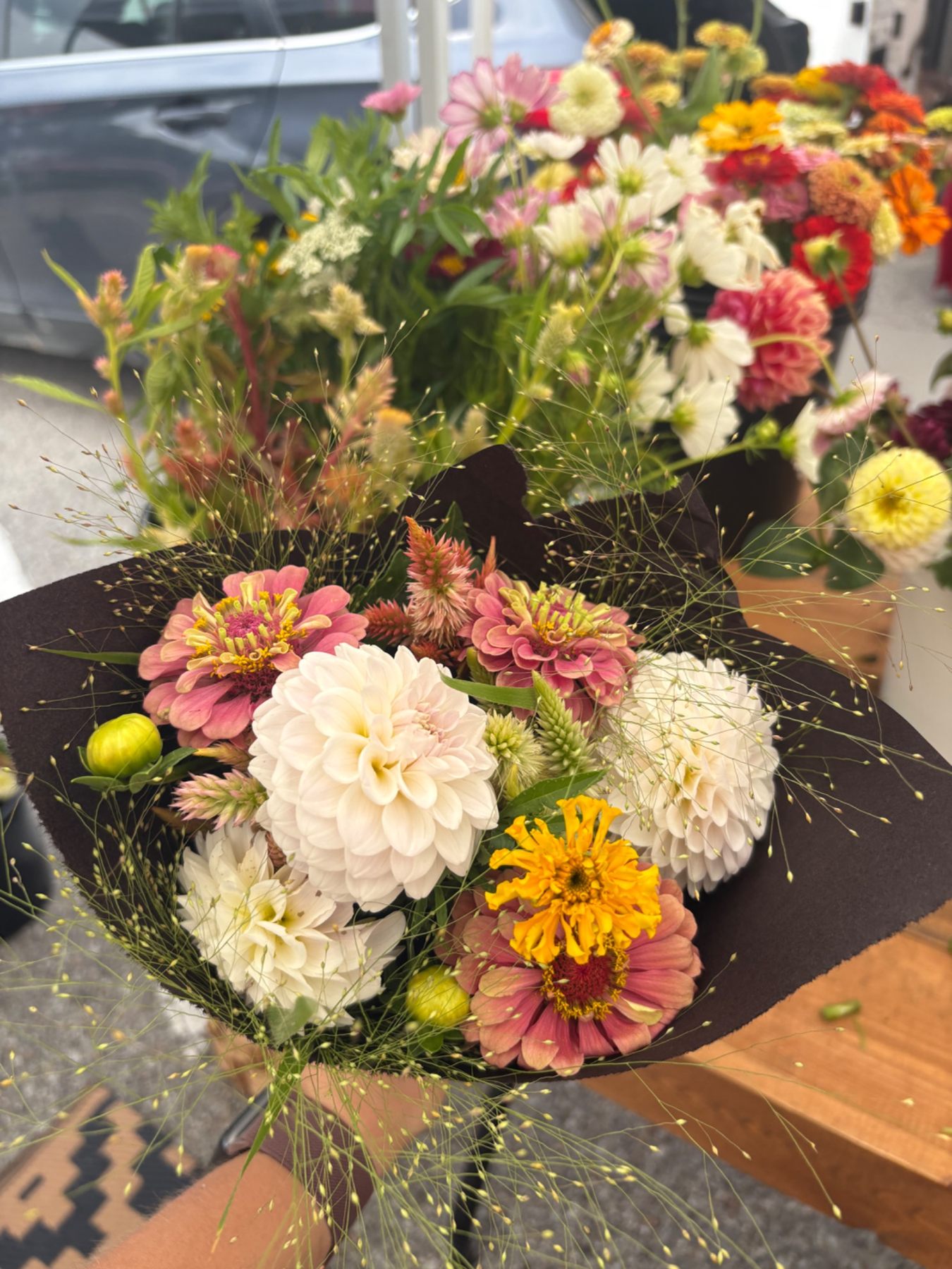 Colorful Rooted Raymond market bouquet wrapped in dark paper